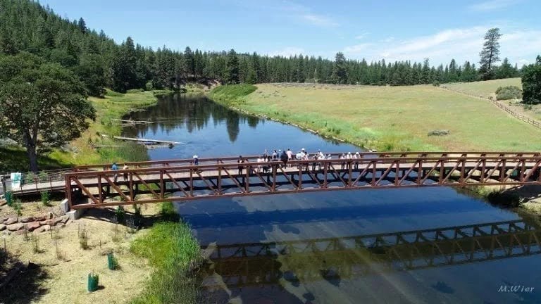 long bridge over hat creek with a group of people in the middle looking down into the water