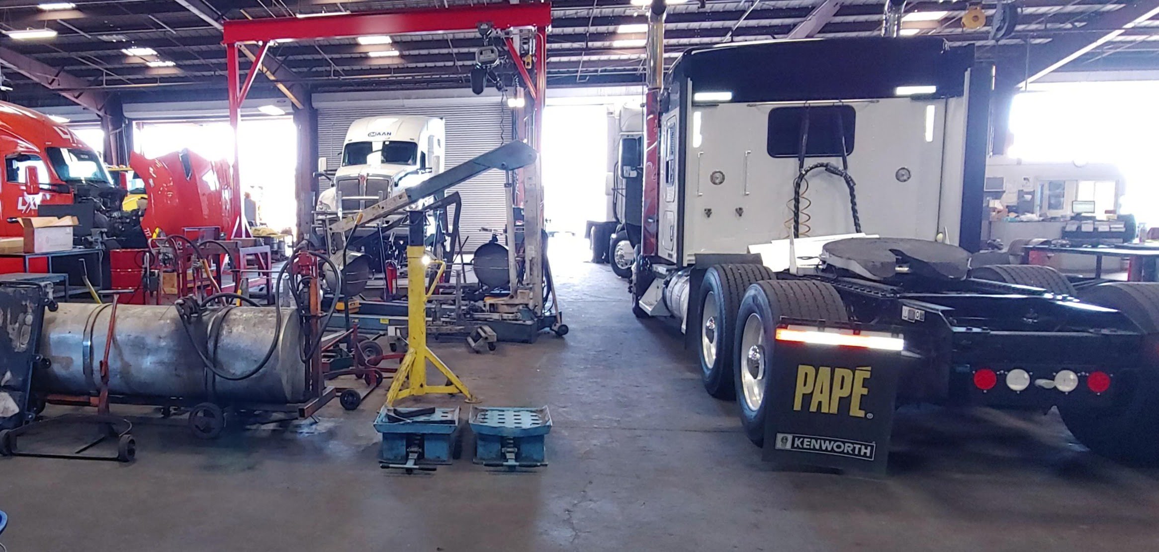 inside a garage with 5 papé trucks